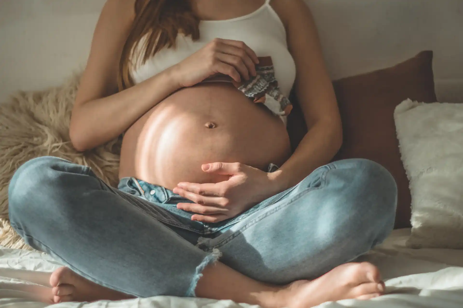 Une femme assise, la main posée sur son ventre